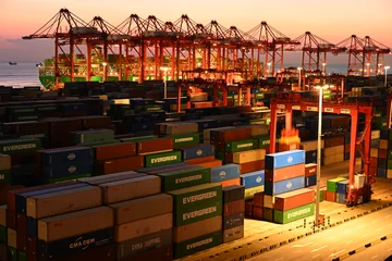 Container cranes and colourful shipping containers in the evening light at Yangshan Port, Shanghai
