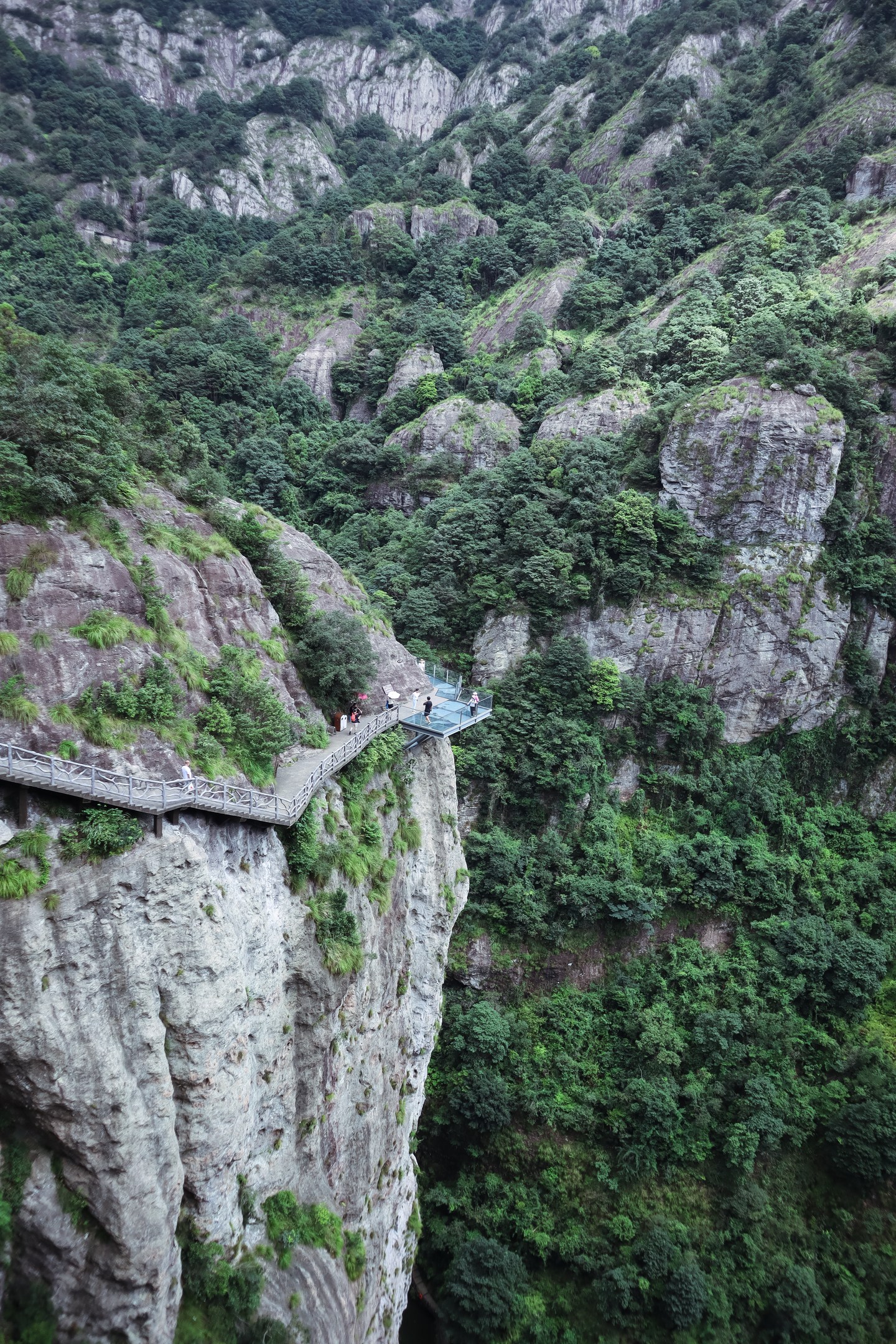 A narrow walkway crossing steep granite cliffs in Laoshan, Qingdao