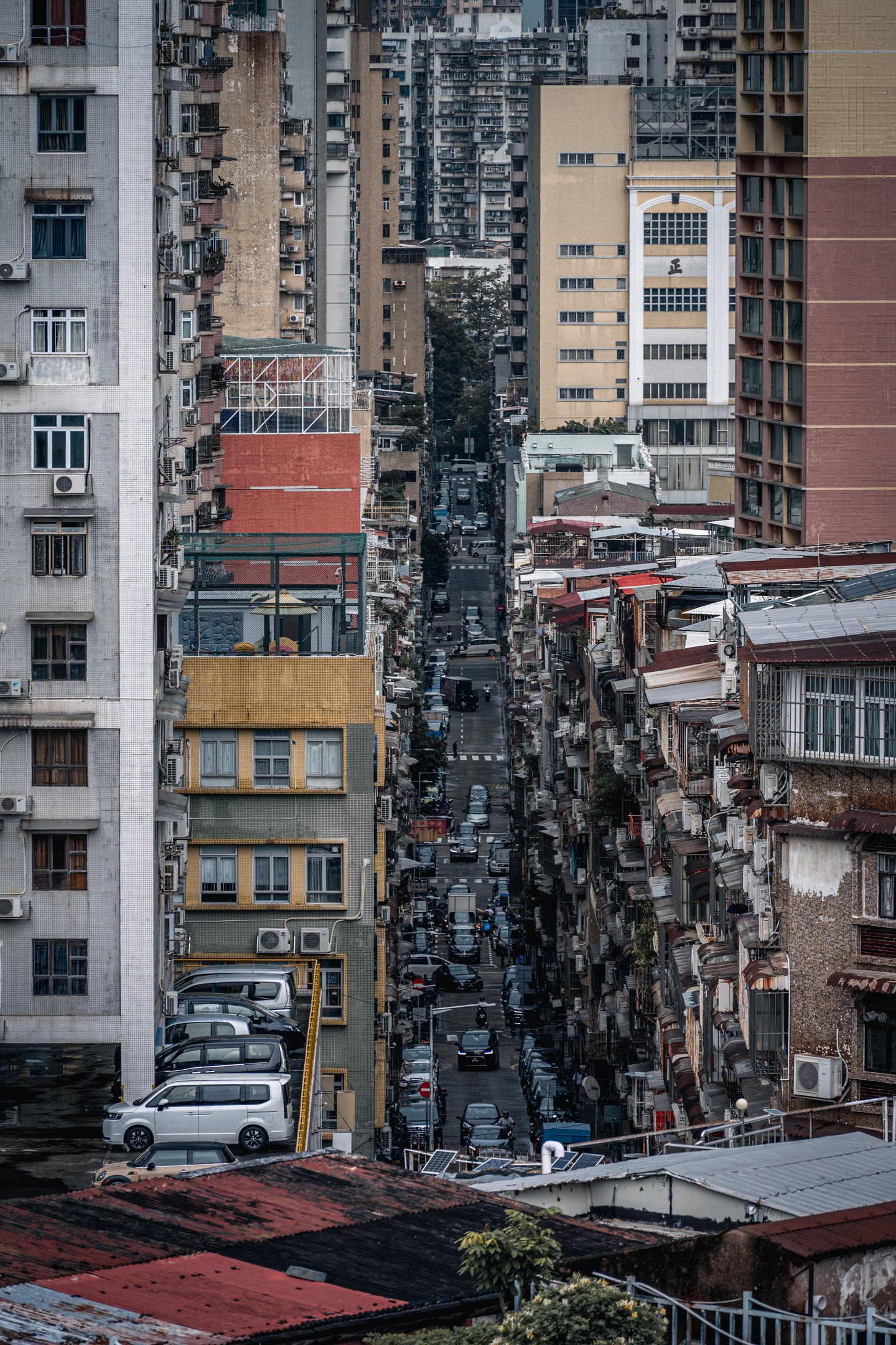 A narrow Macau street between layers of tall residential buildings