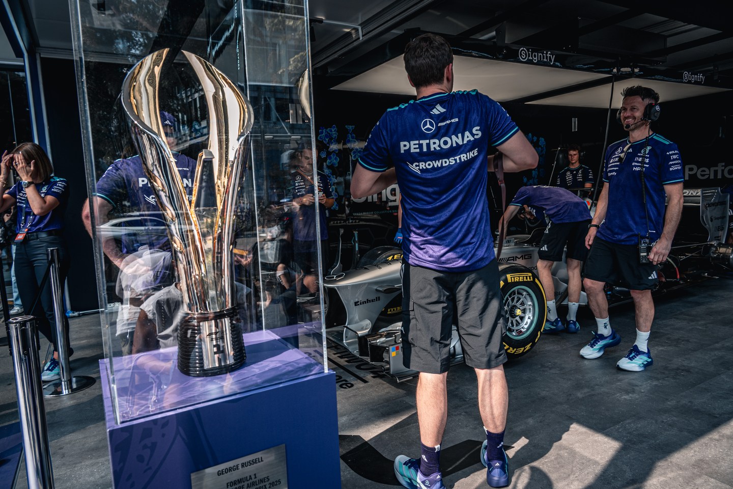 A trophy on display with team members in the background