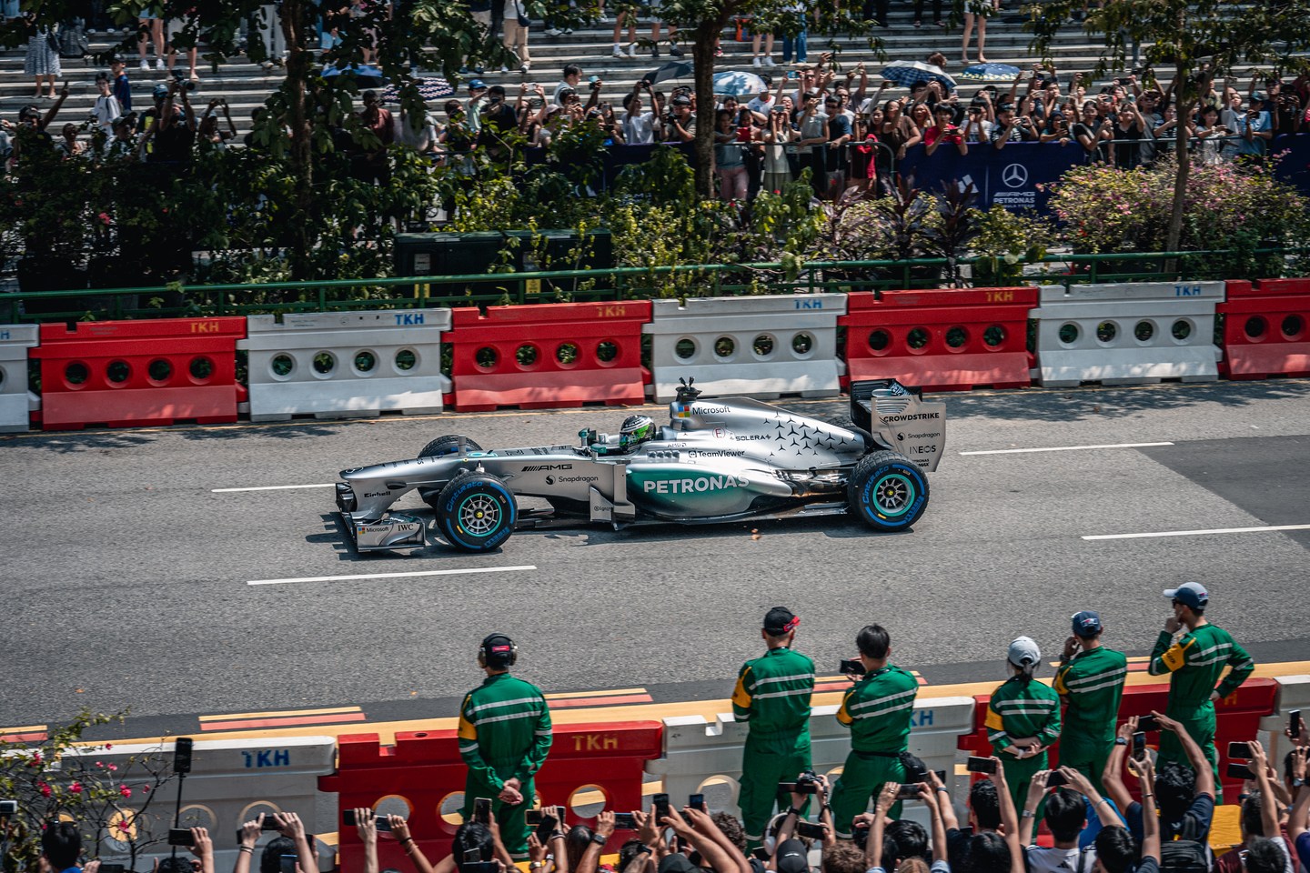 A silver Mercedes Formula 1 car driving past spectators in Singapore