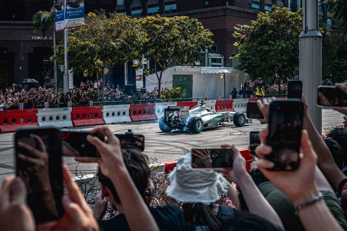 Spectators photographing a Mercedes car on a city street