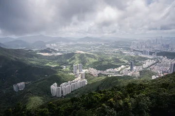 Shenzhen buildings and green hills under a dramatic cloudy sky