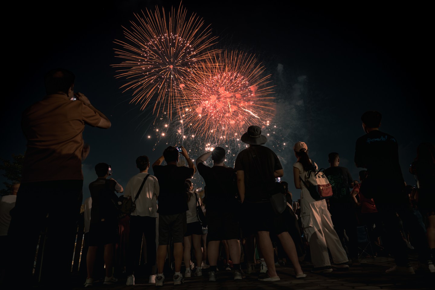 Fireworks above a crowd gathered after dark