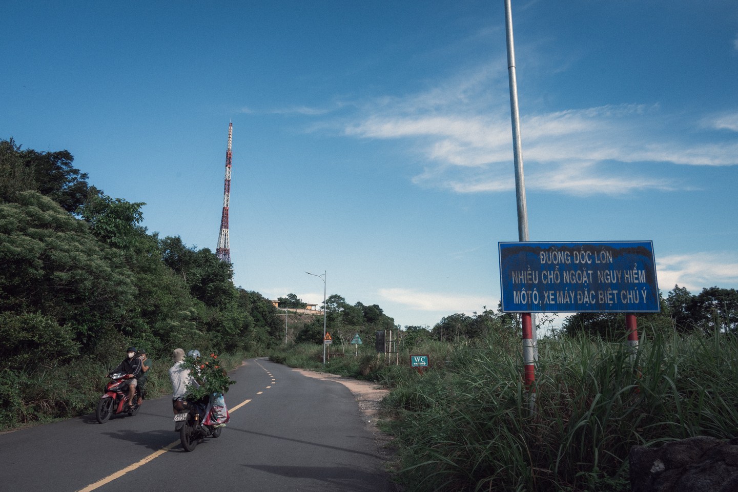 Motorbikes following a road through coastal hills